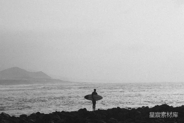 高清摄影 一个人在岩石海滩上拿着冲浪板