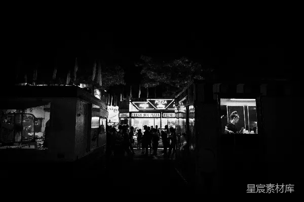 高清摄影 夜间街道上行走的人的黑白照片