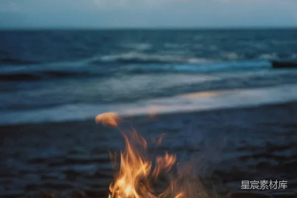 海滩上的篝火，背景是大海。