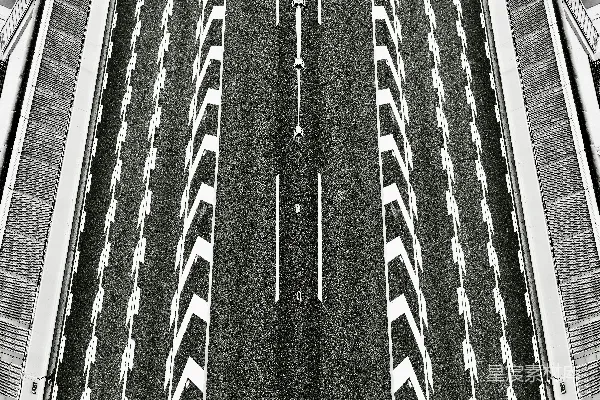 高清摄影 一条高速公路的航拍图，两旁有条纹状的护栏。