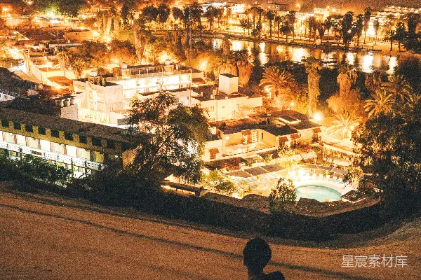 夜晚坐在沙滩上的男人