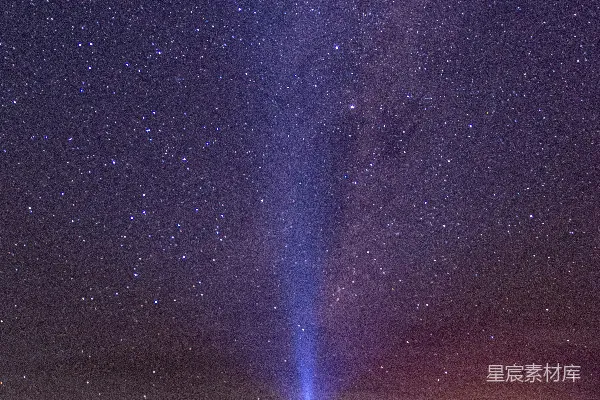 一个人在夜空布满星星的田野中央站立着