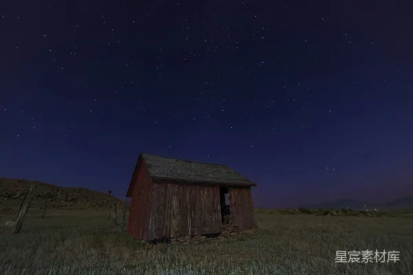 棕色木制小屋坐落在绿色的草地上。