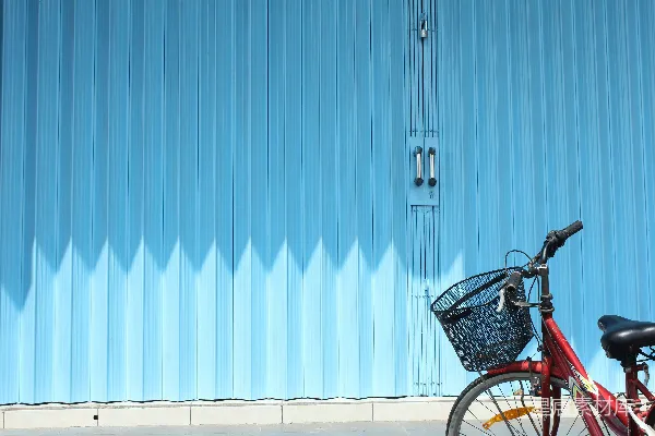 黑色城市自行车停在蓝色和白色墙旁