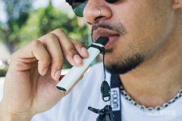 一个戴太阳镜并手持手机接听电话的男子