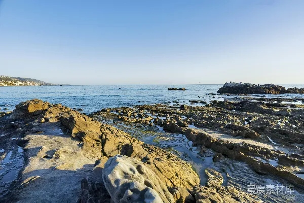 白天岩石海岸在蓝天之下