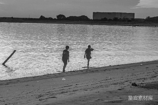 高清摄影 一个手持冲浪板的人在海滩上