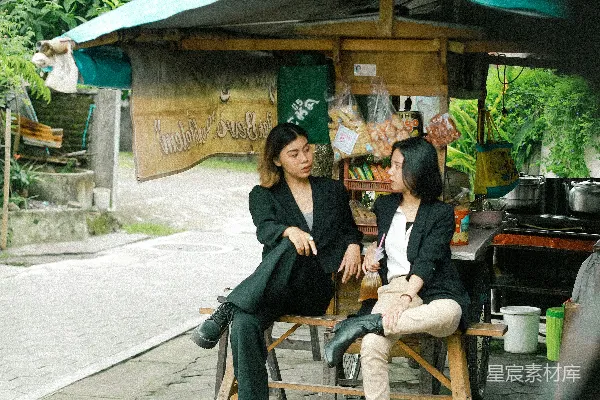 黑色夹克的男人坐在棕色木椅上