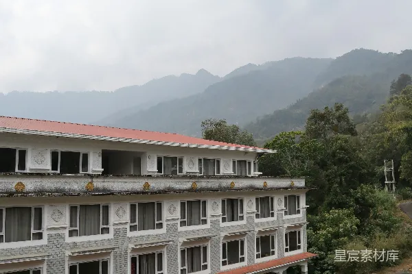 一座巨大的白色建筑矗立在郁郁葱葱的山坡之上。