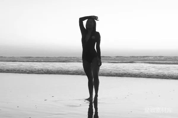 高清摄影 穿着黑色连衣裙的女人在白天的海滩上站着
