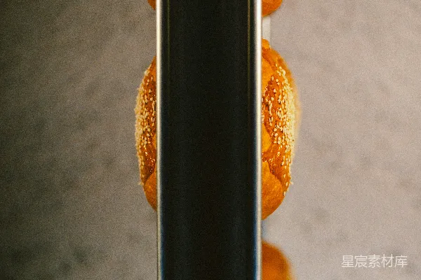几只堆叠在一起的芝麻小圆 bread 竖直放在一根金属杆上。