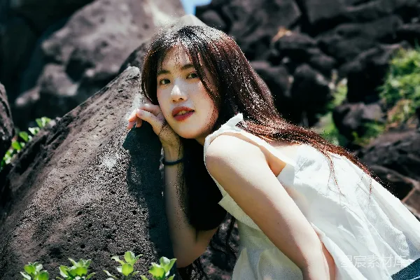 一个女人靠着田地里的岩石斜靠著。
