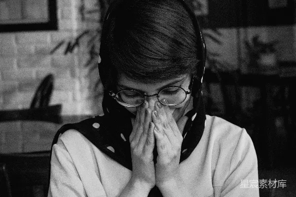 高清摄影 一个戴着眼镜的女人用手捂住脸。