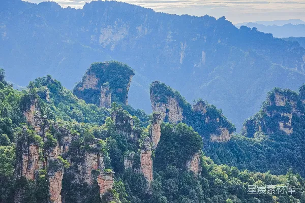 山峦雾气缭绕，独特的岩石形态覆盖着树木。