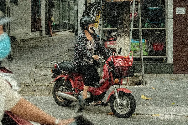 黑白花卉图案的女子骑着红色摩托车在白天的路上行驶。