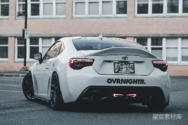 一辆白色 sports 车停在建筑物前面。
