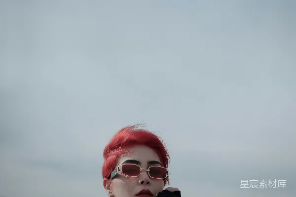 一个红头发的女人戴着太阳镜穿着黑色上衣