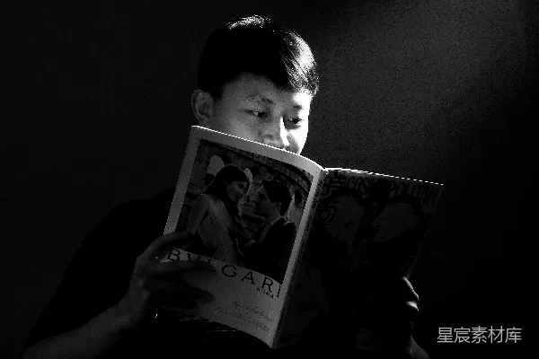 高清摄影 黑白照片中的男孩手里拿着一本书。