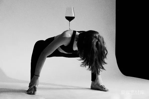 一个女人弯腰拿着酒杯