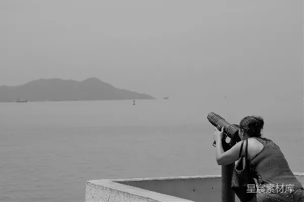 高清摄影 一名女子正在拍摄一片水域的照片。