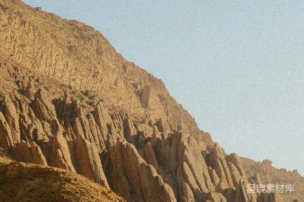 干涸山腰上 jagged 的岩石地貌，在晴朗的天空下。