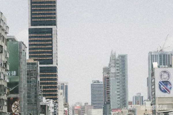 繁忙的城市街道上有高大的建筑物和车辆。