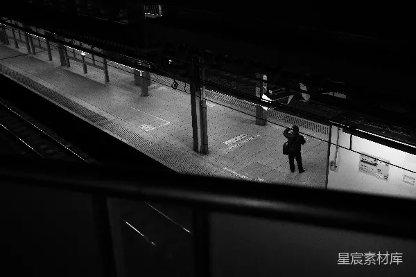 夜晚站在火车站台上的一个人