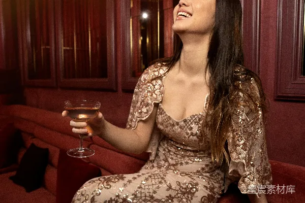 一个女人坐在沙发上拿着一杯红酒。