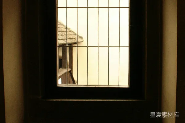 墙上的窗户可以看到一栋房子的风景