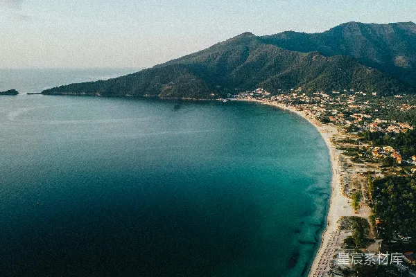 高清摄影 白天，水边有一片绿色的山脉的空中俯瞰图。