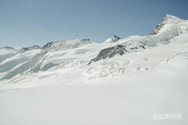 一个男人在覆盖着积雪的山坡上滑翔 Skiing down a snowy slope.