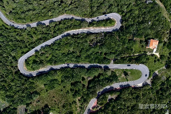 高清摄影 一条蜿蜒的公路俯瞰图，两旁环绕着树木。