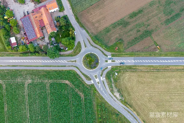 高清摄影 一个圆环连接道路、田野和建筑物的空中俯瞰图。