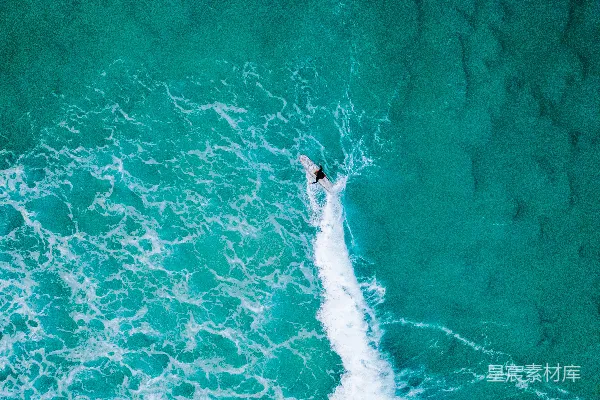 高清摄影 在海洋中，一个人骑着冲浪板在海浪上冲浪。