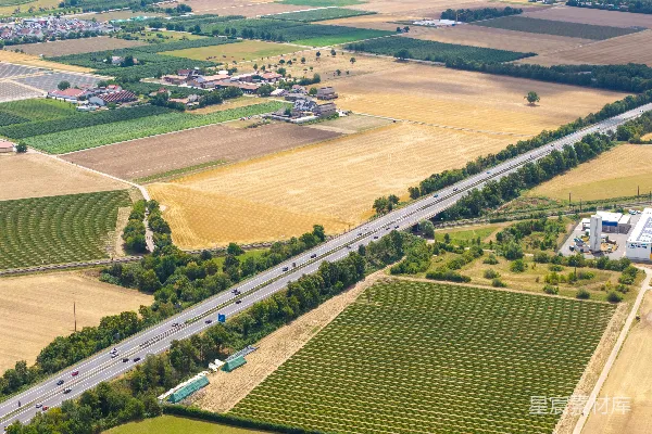 高清摄影 一条高速公路穿越绿色和棕色的田野的空中俯瞰图。