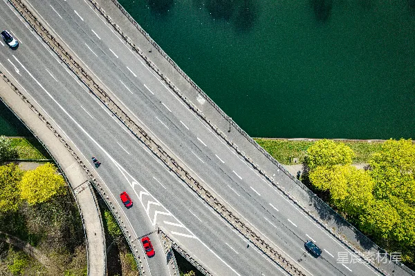 高清摄影 一座绿色河流旁的高速公路立交桥的空中俯瞰图。