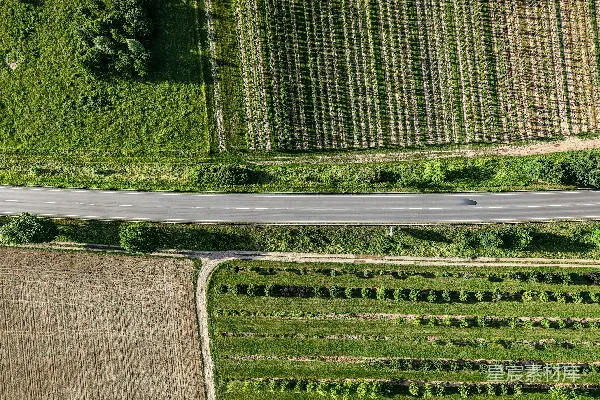 高清摄影 一条道路穿越不同类型的农田的鸟瞰图。