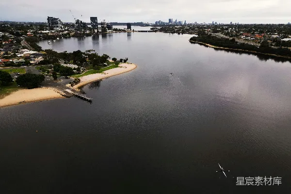 高清摄影 一片水域，背景中有座城市。