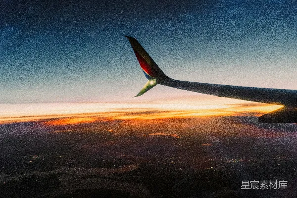 高清摄影 飞机机翼在夕阳的天空下，云层之上