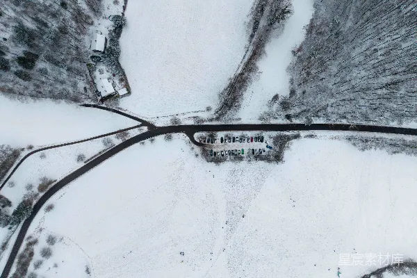 高清摄影 空中俯瞰一片被雪覆盖的景观，可以看到树木和道路。