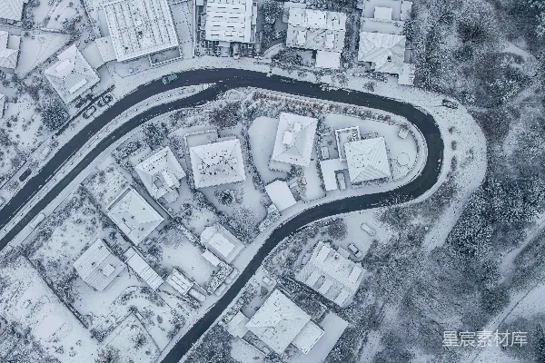 高清摄影 雪覆盖的小镇的航拍图，蜿蜒的道路曲折交错。
