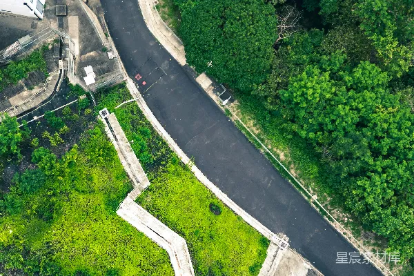 高清摄影 蜿蜒的道路、绿地和树木的俯瞰图。