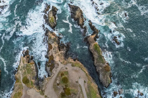 高清摄影 岩石海岸的航拍视角，海浪拍打着海岸。