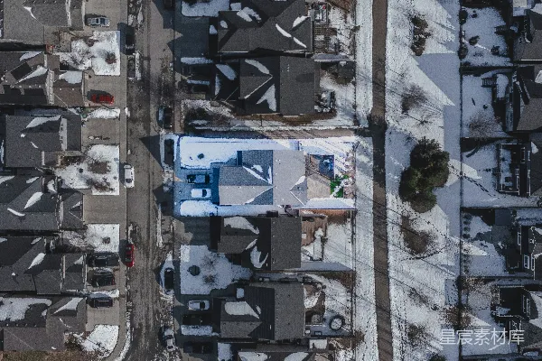 高清摄影 白雪覆盖的住宅区，从上方俯瞰房屋和街道。