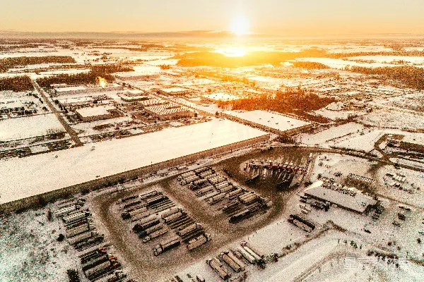 高清摄影 夕阳下，白雪覆盖的工业园区鸟瞰图。