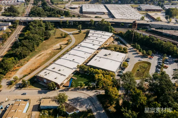 高清摄影 工业建筑的俯瞰图，周围环绕着树木和道路。