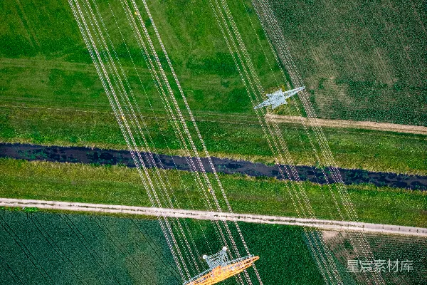 高清摄影 空中俯瞰绿色农田上空的电力线路。