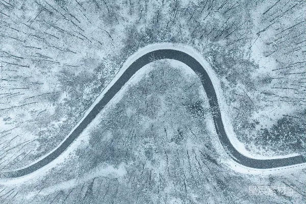 高清摄影 蜿蜒的道路穿过被雪覆盖的森林