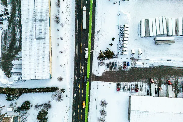 高清摄影 雪覆盖的周围环境中的一条高速公路的空中俯瞰图。