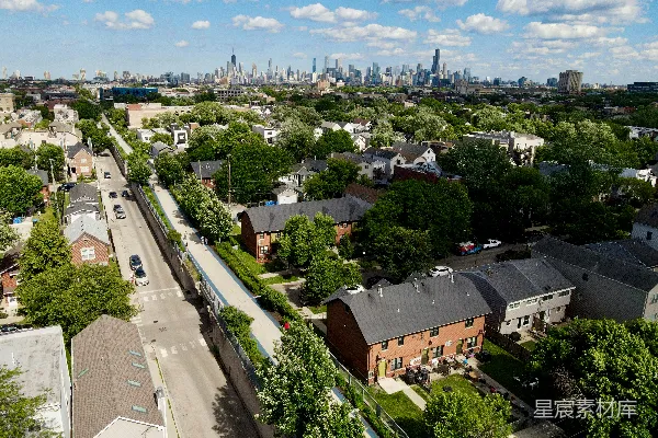 高清摄影 城市天际线在住宅区上方，有一条高架的绿色小径。
